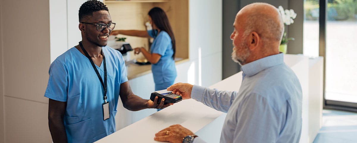 patient paying after his treatment at a dermatology practice